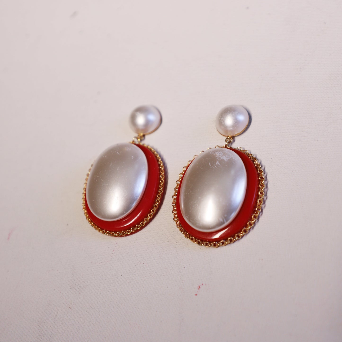 Brinco oval com pérola e resina